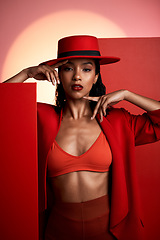 Image showing Beauty, fashion and red aesthetic woman in studio for creative art portrait for makeup, cosmetics and designer brand clothes. Face of 90s edgy style London model in a suit and hat for magazine cover