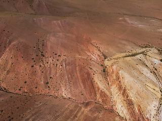 Image showing Aerial shot of the textured yellow nad red mountains resembling the surface of Mars