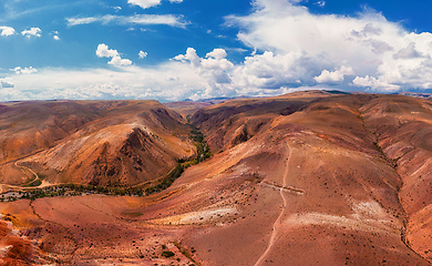 Image showing Aerial shot of the textured yellow nad red mountains resembling the surface of Mars