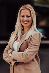 Image showing A powerful portrait of a businesswoman, standing confidently with her arms crossed, representing the determination of the female gender and embodying strength and success