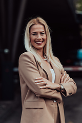 Image showing A powerful portrait of a businesswoman, standing confidently with her arms crossed, representing the determination of the female gender and embodying strength and success