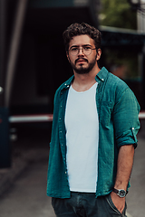 Image showing A portrait of a modern man, exuding confidence and style, against an outdoor backdrop, showcasing his charisma and fashionable demeanor.