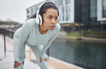 Image showing Headphones, fitness and runner woman on a urban street with motivation, music and exercise. City run, sport and marathon training workout of a black woman athlete listening to web radio for sports