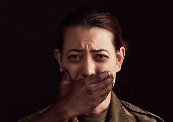 Image showing Abuse, fear and hand over the mouth of a woman in studio on a dark background to stop gender violence. Portrait, mouth and silence with a female victim or hostage as a symbol of domestic violence