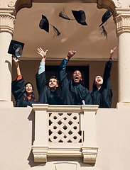 Image showing Graduation hat, university and graduate students at celebration ceremony feeling pride. Education friends, smile and excited class with diversity throw graduation cap in sky happy about certificate