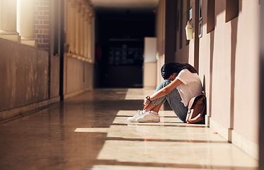 Image showing Sad, lonely and girl with depression at school, crying and anxiety after bullying. Mental health, tired and unhappy student in the corridor after problem in class, education fail and social isolation