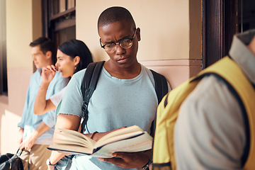 Image showing University, education and black man reading a book in the campus hallway waiting for class. Focus, learning and African male student studying with a textbook in the corridor before a test at college.