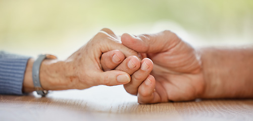 Image showing Elderly couple, holding hands and support for comfort, love or help on table for compassion, pain or sympathy. Senior man, old woman and helping hand with empathy, trust and care in home for bonding