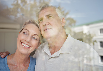 Image showing Hug, thinking and senior couple at a window with vision of future, retirement peace and relax in their home. Idea, love and elderly man and woman with affection in their apartment looking from glass