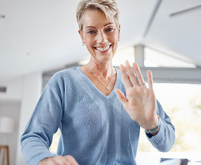 Image showing Senior woman, hand and waving on video call, house zoom conference or social networking communication in house or Canada home. Portrait, smile and happy retirement elderly with hello greeting gesture