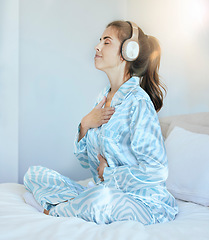 Image showing Woman, morning and headphones for meditation on bed while listening to music or podcast while breathing for chakra exercise in bedroom. Female at home with pajamas with audio for mental health