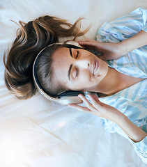 Image showing Top view, woman and headphones in bedroom, morning and relax with mental health podcast, mindfulness audio and zen music. Face of happy, calm and peaceful girl listening to radio, sound and wellness