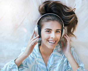 Image showing Top view, woman and headphones in bedroom to relax for morning wellness on podcast, audiobook streaming and music in Australia. Portrait, face and happy girl listening to radio, sound and media track