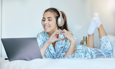 Image showing Woman, video call and heart hand sign of a person in the morning with headphones on a computer. Bedroom bed, smile and happiness of a female in a home feeling happy and relax on digital communication