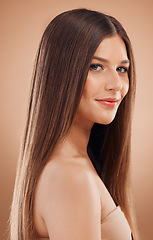 Image showing Woman, beauty and hair in studio with shine, glow and rich keratin aesthetic, textures or color on brown background. Model portrait, hair care and cosmetics, makeup salon or shampoo product of growth