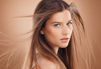 Image showing Woman, cosmetics and skincare for beauty, hygiene and treatment against brown studio background. Female, girl and headshot for scalp massage, wavy and glow for wellness, portrait and head grooming.