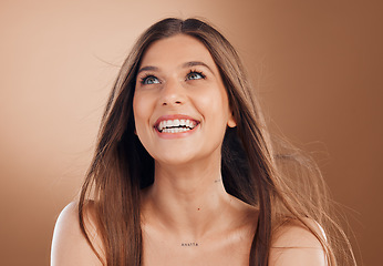 Image showing Hair, beauty and face of woman with smile on brown background for wellness, skincare and luxury spa. Cosmetics, health and happy girl with blowing hairstyle for beauty salon, treatment and hair care