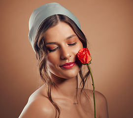 Image showing Rose, woman and face for beauty, natural skincare and cosmetics for floral perfume, aesthetic and eco makeup on studio background. Headshot, model and flowers of nature, spring plants and body glow