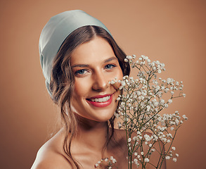 Image showing Woman, face or skincare glow with flowers on studio background in Canada dermatology, organic collagen treatment or fresh self love. Portrait, smile or happy beauty model with plants or satin scarf