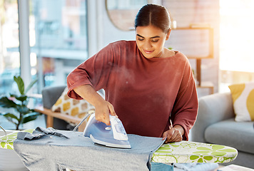 Image showing Laundry, cleaning and woman iron clothes on ironing board for fresh, neat and tidy clothing. Cleaning service, domestic work and happy girl ironing t shirt for housekeeping, maid and housewife chores