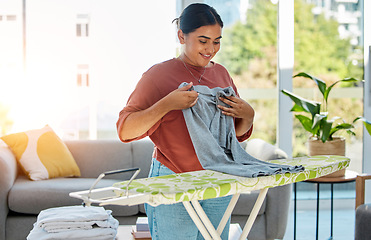 Image showing Woman, laundry and ironing board, cleaning service and domestic worker with happy, smile and working in home. Happiness female, cleaner and housework with clothing, clothes and hygiene in house