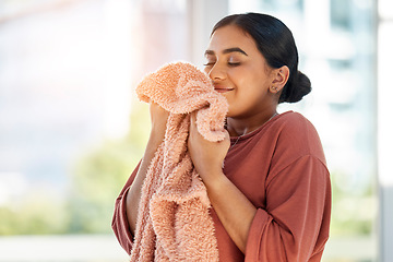 Image showing Woman smelling clean laundry, blanket or fabric for fresh and clean smell in house after doing washing, cleaning and housekeeping. Happy female cleaner with textile for aroma, fragrance and scent