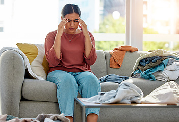 Image showing Woman on sofa, headache with depression and laundry for housework, chores and overworked. Tired, cleaner and maid with clothes, stress and mental health for housekeeping. pain and burnout on couch.