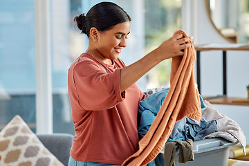 Image showing Cleaning, laundry basket and woman with clothes in home getting ready to wash clothing. Spring cleaning, hygiene and happy female preparing for fabric washing, housework or chores in living room.