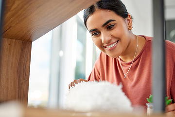 Image showing Woman cleaner, duster and smile by wood, furniture or display in living room, home or hotel. House work, cleaning expert and happiness with shelf, dust and dirt with hospitality service in apartment