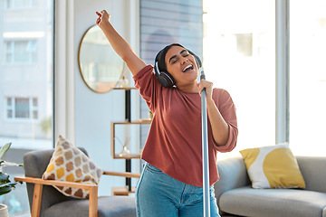 Image showing Music, headphones and woman singing while cleaning home, dancing and having fun. Singer, dance and female spring cleaning for hygiene holding broom like microphone, sweeping dust and streaming radio.
