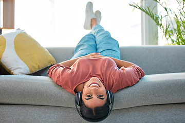 Image showing Woman, sofa and relax with headphones, music and smile in portrait while upside down in lounge. Happy lady, couch and lying for happiness, streaming podcast or web radio in home living room in Mexico