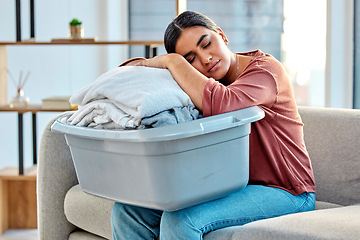 Image showing Woman, sleeping and laundry basket on sofa from cleaning, folded washing clothes or housework at home. Tired woman asleep on washed clothing or garments from housekeeping, hygiene or living room rest