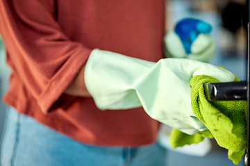 Image showing Hand, woman and sanitizing with spring cleaning a door handle surface with a cloth. Busy with routine housework and chores with zoom, hygiene and germ free living space, glove and clean bacteria