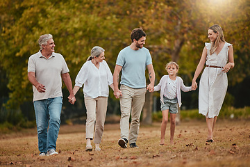 Image showing Family, walking and holding hands outdoor with mother, dad and girl happy with grandparents. Happy family, love and parent care in nature with a child in a grass field park in autumn on holiday