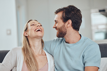 Image showing Couple, laughing and home of a woman and man in a living room with love, happiness and care. House, relax and funny joke of a happy couple on a house sofa smile about bonding and marriage together