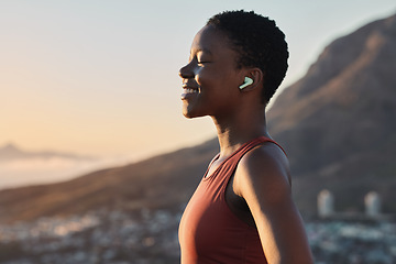 Image showing Headphones, fitness or zen black woman on a mountain for peaceful, calm and breathing in relaxing fresh air. Breathe, healthy or happy sports athlete with smile streaming radio music, song or podcast