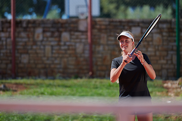 Image showing A young girl showing professional tennis skills in a competitive match on a sunny day, surrounded by the modern aesthetics of a tennis court.