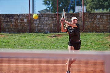 Image showing A young girl showing professional tennis skills in a competitive match on a sunny day, surrounded by the modern aesthetics of a tennis court.