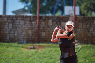 Image showing A young girl showing professional tennis skills in a competitive match on a sunny day, surrounded by the modern aesthetics of a tennis court.