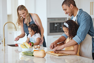 Image showing Family, mother and father with girls, vegetables or cooking together, interracial or bonding. Love, man and woman happy with daughters, cutting or rinse veggies in kitchen, child development or relax