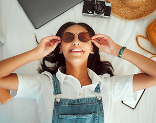 Image showing Travel packing, woman and happiness of a person with sunglasses on a hotel bed ready for adventure. Clothing, technology and suitcase pack break with a solo traveler above view happy about journey