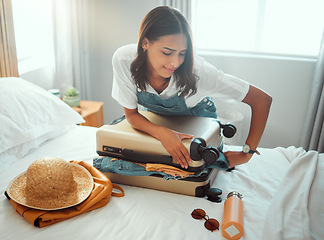 Image showing Woman, overloaded suitcase and luggage bag in bedroom for travel, vacation and international journey, holiday and trip. Female tourist struggle to close baggage full of clothing, packing and problem