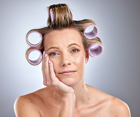Image showing Woman, face and waiting for hair roller set, bored and hair style on studio background. Portrait of model, hair care and curlers for cosmetics, beauty salon treatment and makeup product on backdrop