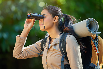 Image showing Woman hiking, binocular and vision in forest with backpack, camping gear and smile on nature journey. Happy hiker girl, bird watching and trekking in woods for adventure, fitness and health in Amazon