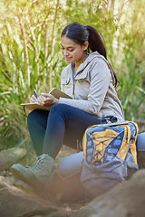 Image showing Hiking, travel and woman writing in book sitting outdoors in nature. Freedom, hiker and happy female from India with personal diary, notebook or journal to write ideas, thoughts or journey experience