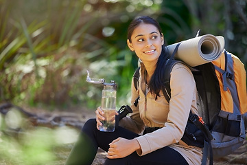 Image showing Drinking water, hiking and backpack with an indian woman in nature for exercise or a recreation hobby. Fitness, forest and workout with a young female taking a break to relax during a hike outdoor