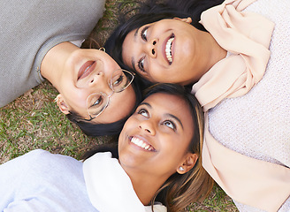 Image showing Faces, group and women lying on the ground in a park for cheerful bonding with love and care. Friendship, overhead and female hangout in a garden outdoors for bond and relationship in nature
