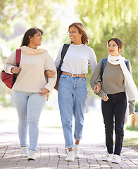Image showing Friends, women and students outdoor, walking and conversation on break, relax and smile. Young females, girls and in nature for peace, bonding together and stroll on pathway, casual and trendy look.