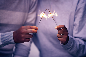 Image showing Sparklers, hands and couple celebration with lights, sparks and magic for new years evening, love and anniversary. Closeup man, woman and people celebrate with sparkles, fireworks and glow with shine