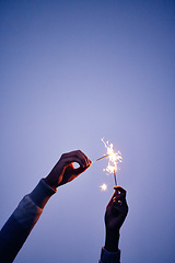 Image showing Sparkler, fire and hands of a person on a blue sky, celebration with light and outdoor party at night. Creative, color and woman with fireworks to celebrate in nature during sunset at new years